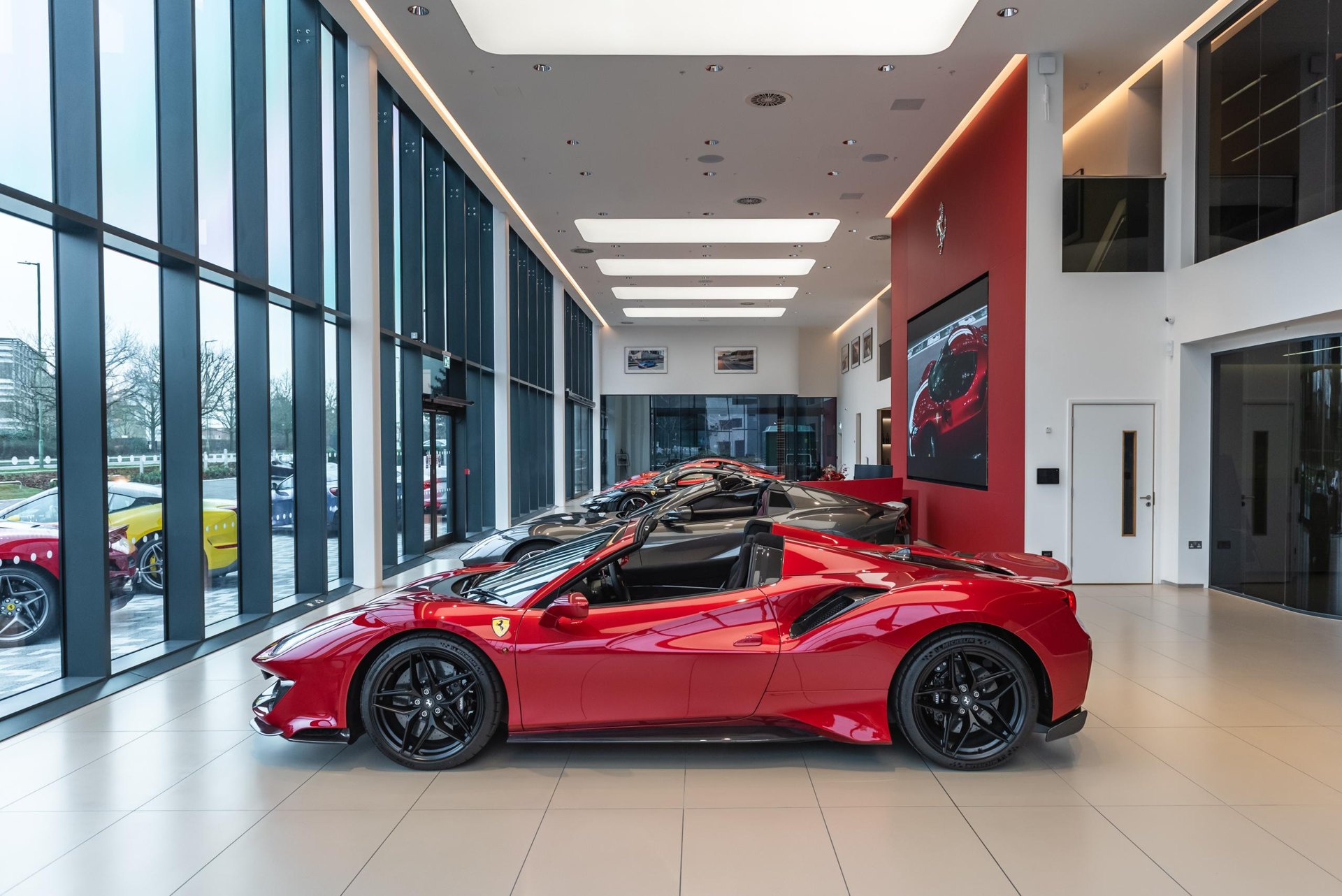 A red Ferrari in the glass-walled showroom at Ferrari Mayfair