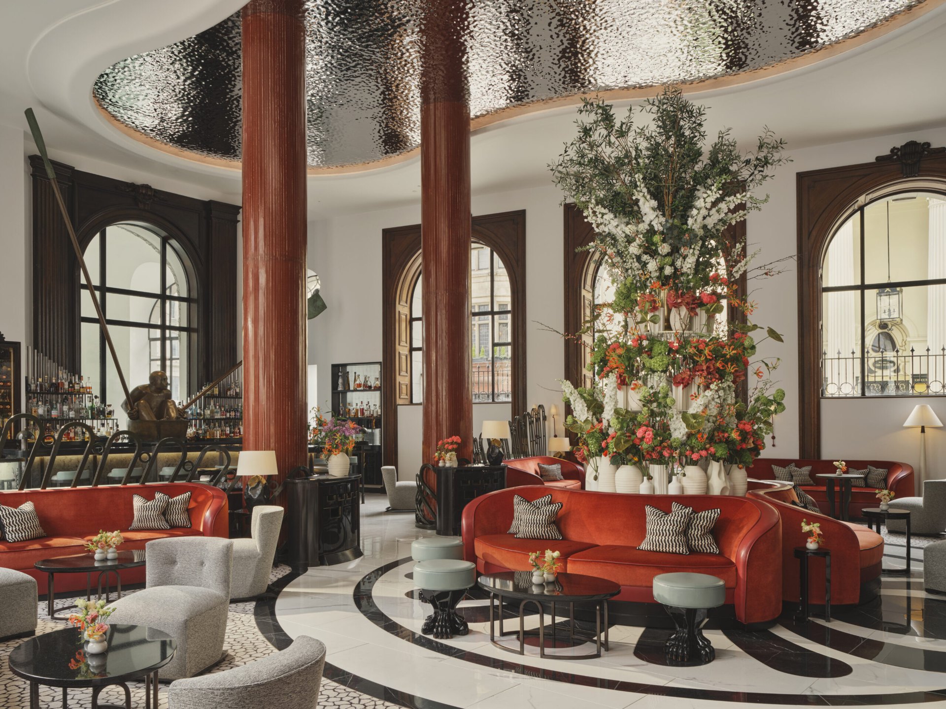 The lobby of One Aldwych, under a silver-leaf ceiling with a tower of flowers