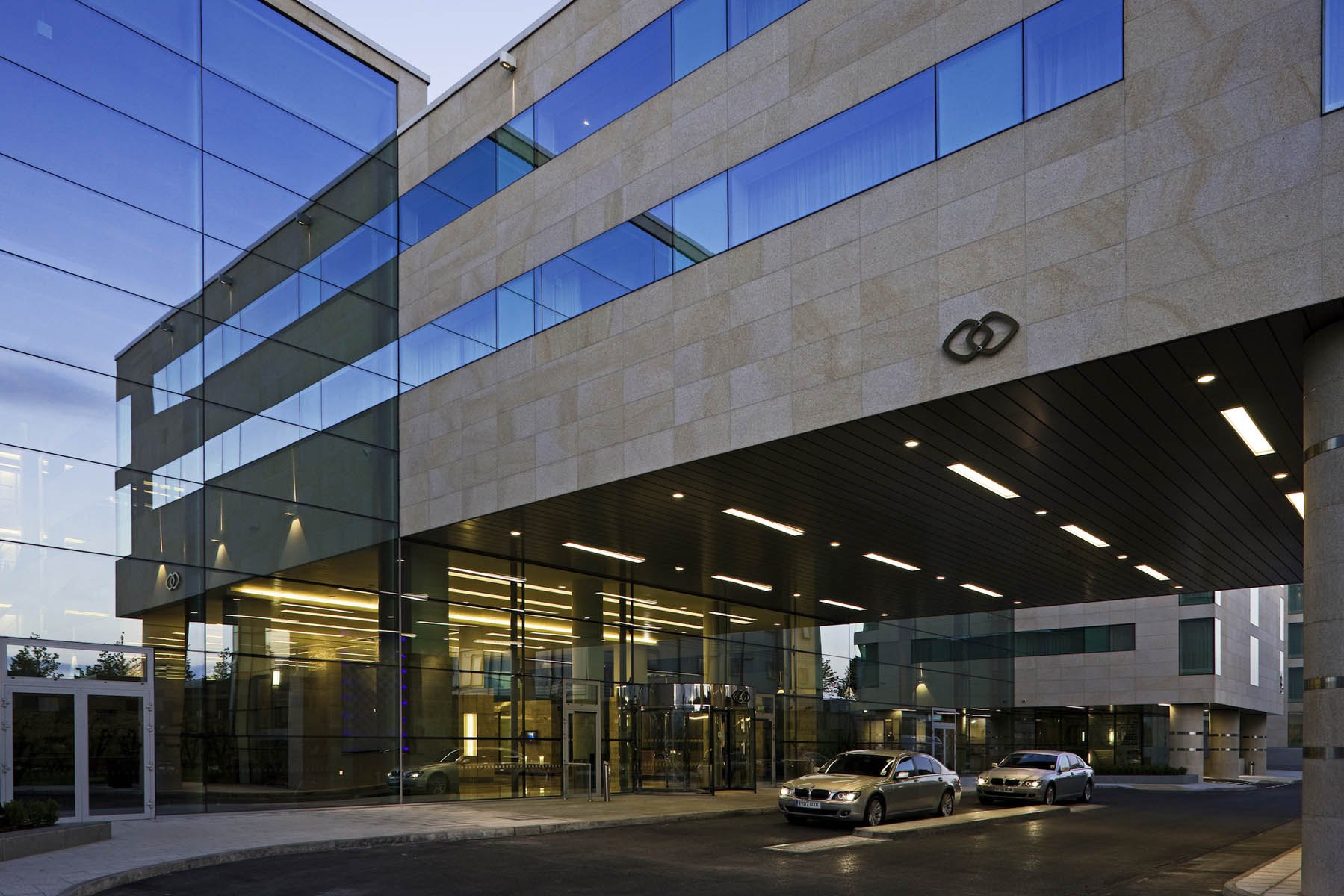 The glass and stone entrance canopy of Sofitel London Heathrow at dusk