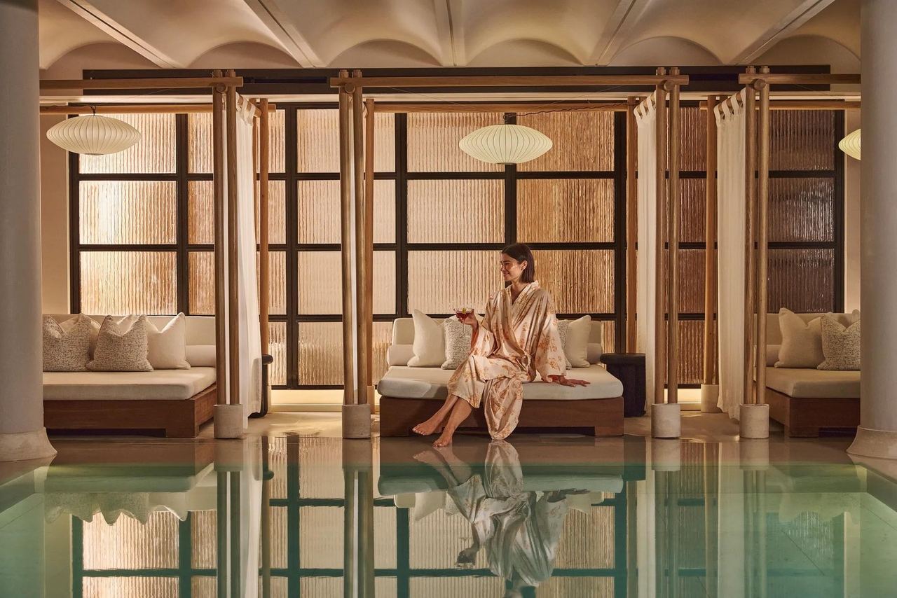 A guest in a robe in a poolside cabana at Claridge’s Spa
